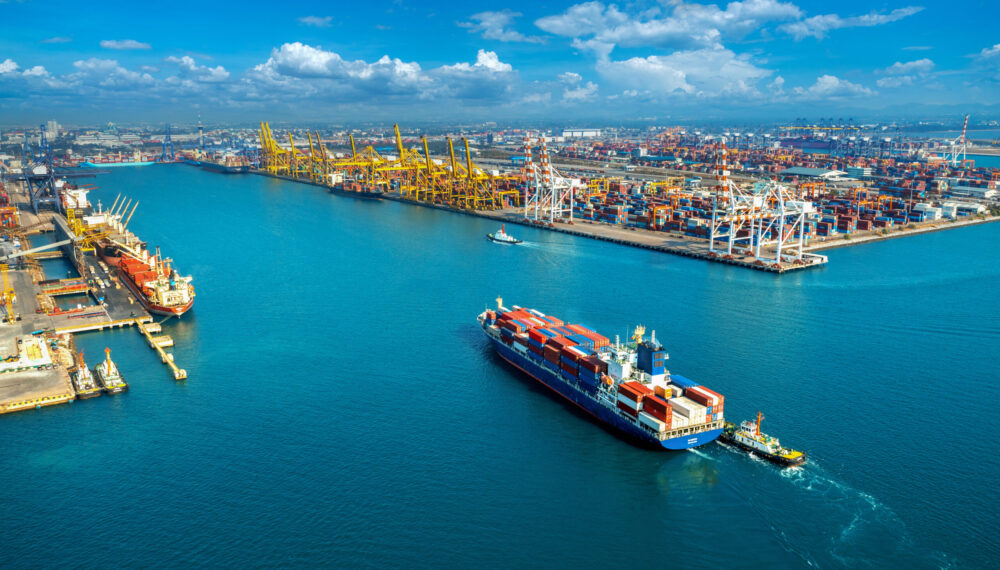 Aerial view of cargo ship and cargo container in harbor.